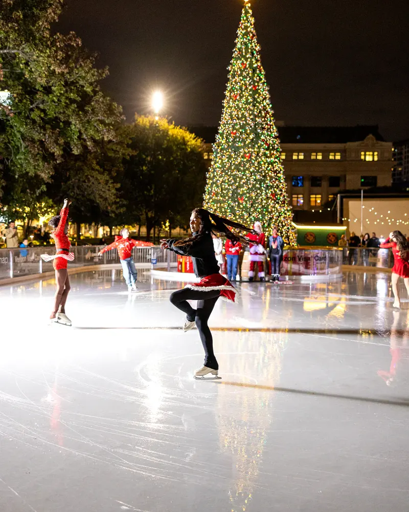 Holiday ice-skating performance in front of the illuminated Christmas tree